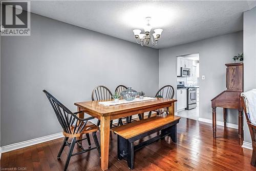 Dining space featuring dark wood finished floors, a textured ceiling, and suspended lighting - 65 Thistlemoor Drive, Caledonia, ON - Indoor Photo Showing Dining Room
