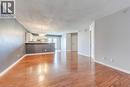Unfurnished living room featuring a textured ceiling, light wood-type flooring, and hanging lights - 1411 Walker'S Line Unit# 302, Burlington, ON  - Indoor 