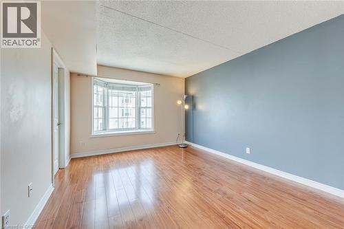 Unfurnished room with light wood-style floors and a textured ceiling - 1411 Walker'S Line Unit# 302, Burlington, ON - Indoor Photo Showing Other Room