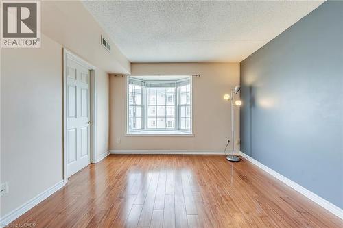 Empty room featuring a textured ceiling and light wood-style floors - 1411 Walker'S Line Unit# 302, Burlington, ON - Indoor Photo Showing Other Room