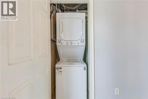Laundry area with stacked washing machine and dryer - 1411 Walker'S Line Unit# 302, Burlington, ON - Indoor Photo Showing Laundry Room