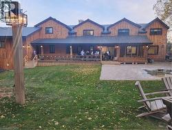 Back of house with a lawn, an outdoor fire pit, a metal roof, board and batten siding, and a patio area - 