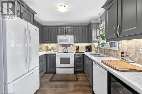 Kitchen featuring white appliances, gray cabinetry, backsplash, and dark wood-style flooring - 3753 Densbury Drive, Mississauga, ON - Indoor Photo Showing Kitchen With Double Sink