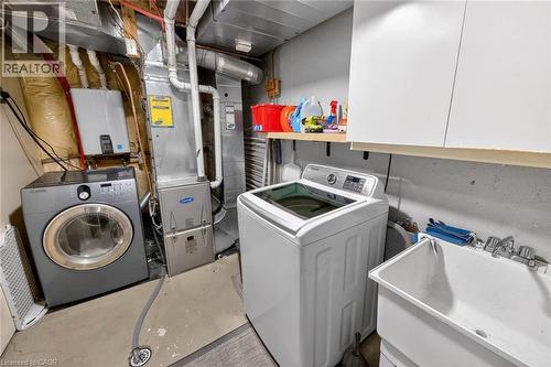 Laundry room featuring unfinished concrete flooring, tankless water heater, and heating unit - 3753 Densbury Drive, Mississauga, ON - Indoor Photo Showing Laundry Room