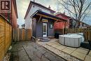 Rear view of property featuring a patio area, entry steps, a fenced backyard, a hot tub, and a chimney - 97 Keith Street, Hamilton, ON  - Outdoor 