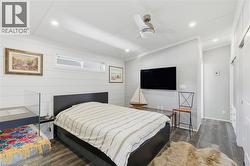 Bedroom featuring dark wood-type flooring, crown molding, recessed lighting, a ceiling fan, and vaulted ceiling - 