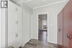Hallway featuring dark wood finished floors and crown molding - 