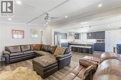 Living area with light wood finished floors, recessed lighting, and crown molding - 