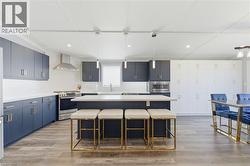 Kitchen featuring a kitchen island, pendant lighting, light countertops, and stainless steel appliances - 