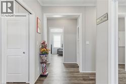 Corridor featuring dark wood-style flooring and ornamental molding - 