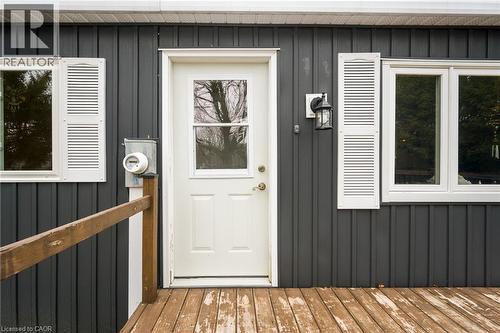 Property entrance featuring board and batten siding and a wooden deck - 157 Maple Crescent, Hamilton, ON - Outdoor With Exterior