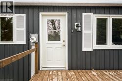 Property entrance featuring board and batten siding and a wooden deck - 