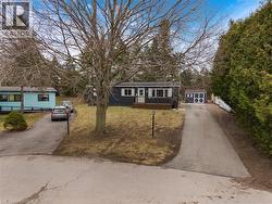 View of front of house featuring a front lawn, asphalt driveway, an outbuilding, and a deck - 