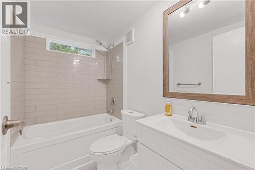Bathroom featuring a white vanity with integrated sink, chrome faucet, and a large wood-framed mirror - 157 Maple Crescent, Hamilton, ON - Indoor Photo Showing Bathroom