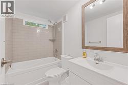 Bathroom featuring a white vanity with integrated sink, chrome faucet, and a large wood-framed mirror - 
