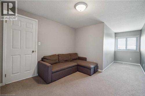 Living room with light carpet and a textured ceiling - 27 Red Clover Crescent, Kitchener, ON - Indoor