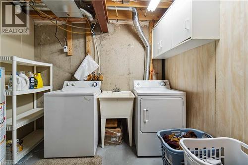 Laundry area with concrete flooring, washer and dryer, and cabinet space - 27 Red Clover Crescent, Kitchener, ON - Indoor Photo Showing Laundry Room