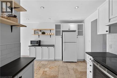 Kitchen featuring decorative backsplash, white cabinetry, open shelves, dark countertops, and recessed lighting - 216 Robert Street, Hamilton, ON - Indoor Photo Showing Kitchen