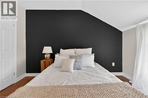 Bedroom featuring an accent wall, lofted ceiling, and dark wood-style flooring - 216 Robert Street, Hamilton, ON - Indoor Photo Showing Bedroom