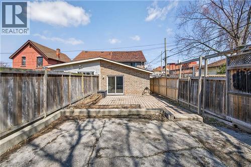 Rear view of property featuring a fenced backyard, brick siding, and a wooden deck - 216 Robert Street, Hamilton, ON - Outdoor