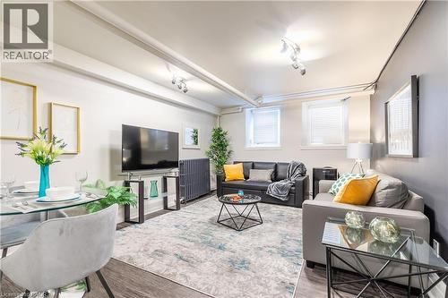 Living room featuring rail lighting and wood finished floors - 14 Duke Street, Hamilton, ON - Indoor