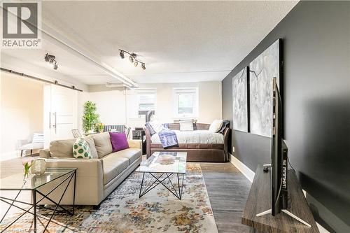 Living room featuring a barn door, a textured ceiling, and wood finished floors - 14 Duke Street, Hamilton, ON - Indoor Photo Showing Living Room
