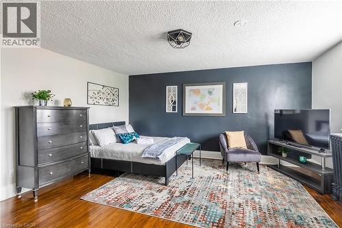 Bedroom with dark wood finished floors and a textured ceiling - 14 Duke Street, Hamilton, ON - Indoor Photo Showing Bedroom
