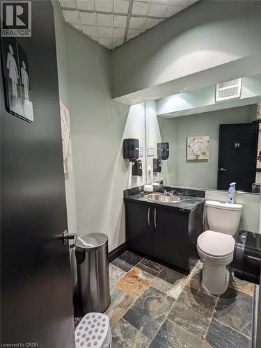 Half bathroom featuring vanity, stone tile flooring, and a paneled ceiling - 14 Duke Street, Hamilton, ON - Indoor