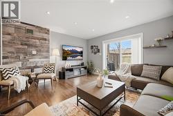 Living room with wood finished floors, wooden walls, recessed lighting, and an accent wall - 