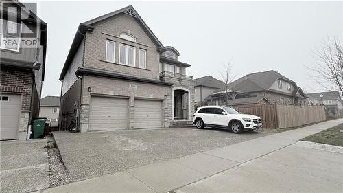 View of front of home featuring brick siding, an attached garage, driveway, and a residential view - 110 Rivertrail Avenue, Kitchener, ON - Outdoor