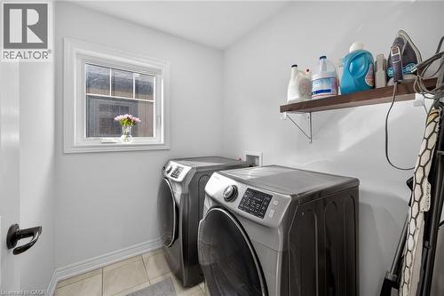 Laundry area with washing machine and dryer and light tile patterned floors - 80 Severino Circle, Smithville, ON - Indoor Photo Showing Laundry Room