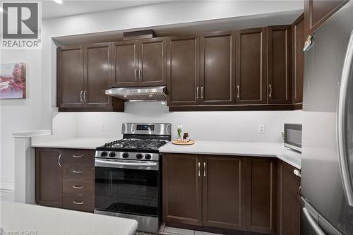 Kitchen with stainless steel appliances, dark wood finish cabinetry, and light countertops - 80 Severino Circle, Smithville, ON - Indoor Photo Showing Kitchen