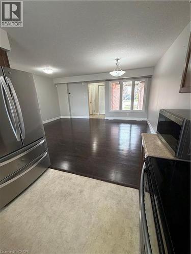 Kitchen with stainless steel appliances, open floor plan, light countertops, dark wood-style floors, and dark wood finish cabinetry - 45 Brookfield Crescent, Kitchener, ON - Indoor