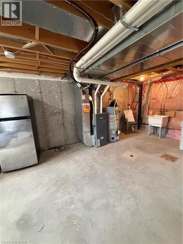 Unfinished below grade area featuring freestanding refrigerator, heating unit, and water heater - 45 Brookfield Crescent, Kitchener, ON - Indoor Photo Showing Basement