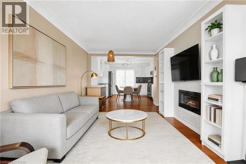 Virtual Staging. The living area features hardwood floors, a built-in fireplace, and integrated shelving units - 420 Waverly Street, Hamilton, ON - Indoor Photo Showing Living Room With Fireplace