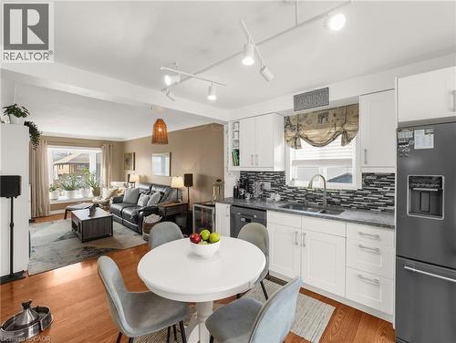 Kitchen with fridge with ice dispenser, white cabinetry, open floor plan, dark stone counters, and track lighting - 420 Waverly Street, Hamilton, ON - Indoor Photo Showing Other Room