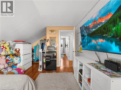 Bedroom featuring dark wood-type flooring, freestanding refrigerator, and lofted ceiling - 420 Waverly Street, Hamilton, ON - Indoor