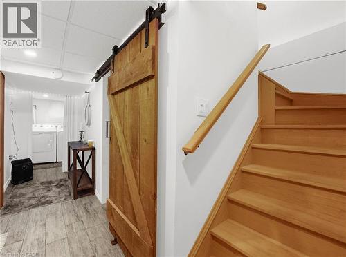 Stairs with a barn door, washer and dryer, wood finished floors, a paneled ceiling, and recessed lighting - 420 Waverly Street, Hamilton, ON - Indoor Photo Showing Other Room