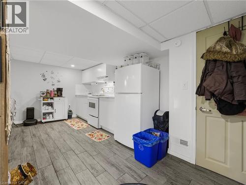 Kitchen featuring a drop ceiling, white appliances, light wood-type flooring, white cabinetry, and open shelves - 420 Waverly Street, Hamilton, ON - Indoor