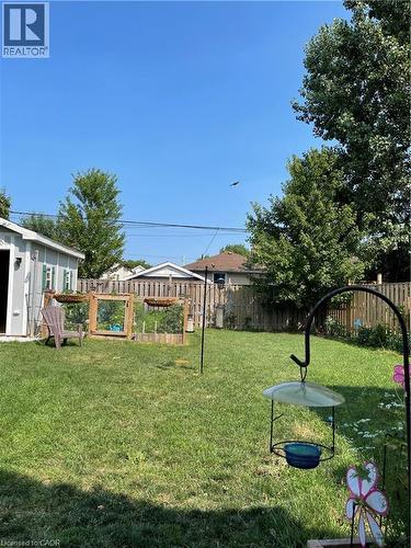 The property features a spacious backyard with a well-maintained lawn and a wooden fence - 420 Waverly Street, Hamilton, ON - Outdoor
