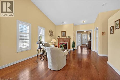 Living room with hardwood / wood-style floors, a fireplace, and lofted ceiling - 48 Hallmark Trail, Hamilton, ON - Indoor With Fireplace