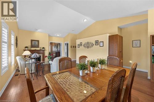 Dining area with dark wood-style floors, lofted ceiling, and a fireplace - 48 Hallmark Trail, Hamilton, ON - Indoor Photo Showing Dining Room