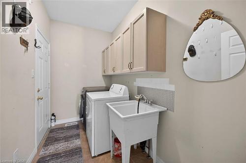 Laundry area featuring cabinet space, washer and clothes dryer, and light tile patterned flooring - 48 Hallmark Trail, Hamilton, ON - Indoor Photo Showing Laundry Room