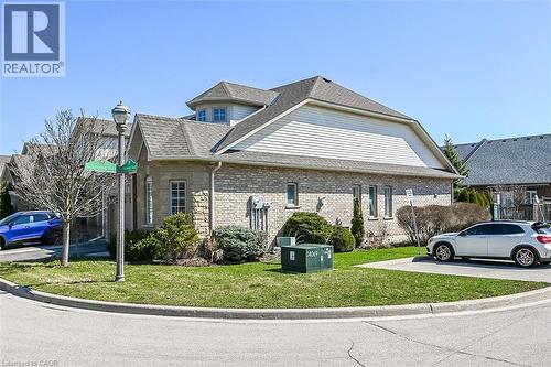 View of home's exterior featuring a lawn, a shingled roof, and brick siding - 48 Hallmark Trail, Hamilton, ON - Outdoor