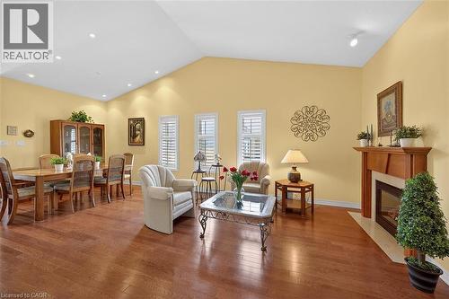 Living area with a fireplace with flush hearth, hardwood / wood-style flooring, vaulted ceiling, and recessed lighting - 48 Hallmark Trail, Hamilton, ON - Indoor With Fireplace