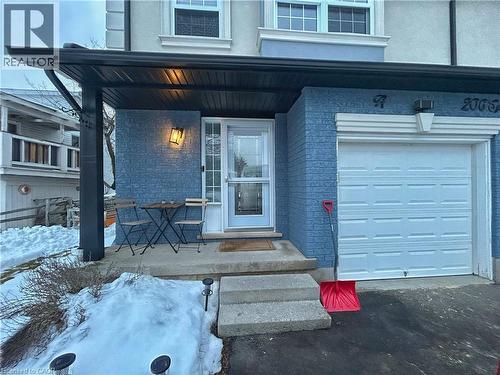 Property entrance with a porch, stucco siding, and a garage - 206A Springfield Crescent Unit# Lower, Waterloo, ON - Outdoor