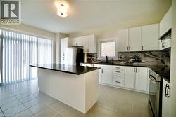 Kitchen with a center island, electric range, tasteful backsplash, white cabinetry, and a textured ceiling - 
