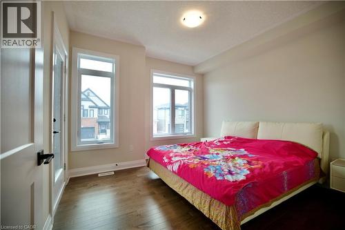 Bedroom featuring dark wood finished floors and a textured ceiling - 559 Balsam Poplar Street, Waterloo, ON - Indoor Photo Showing Bedroom