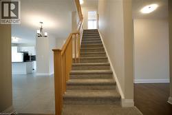 Staircase featuring hanging lights and a textured ceiling - 