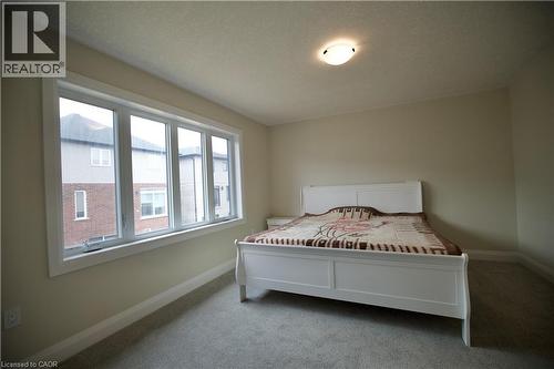 Carpeted bedroom featuring baseboards and a textured ceiling - 559 Balsam Poplar Street, Waterloo, ON - Indoor Photo Showing Bedroom